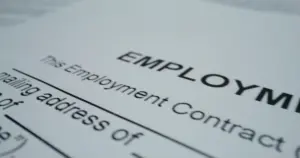 A close up of an employment contract outlining what employees are entitled to under the CA Fair Employment and Housing Act.