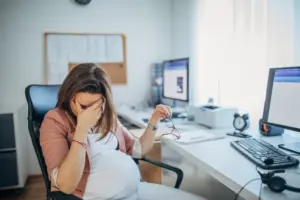 A pregnant woman stressing out at work.