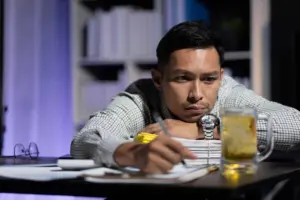 A worried man hunched over and scribbling.