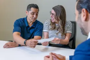 A pair of clients receiving a good settlement check from their attorney.