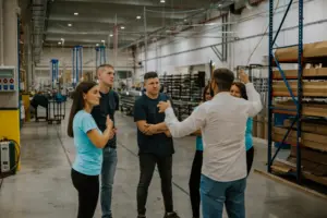 A group of employees talking about something in the middle of warehouse.