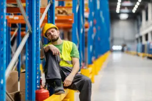 An overworked warehouse worker resting for a moment.