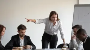 A woman yelling at one of her employees to get out during a meeting.