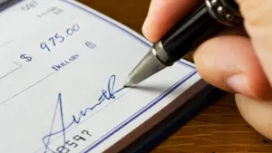 A person signing a check.