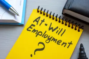 A yellow notepad that says "At Will Employment?"
