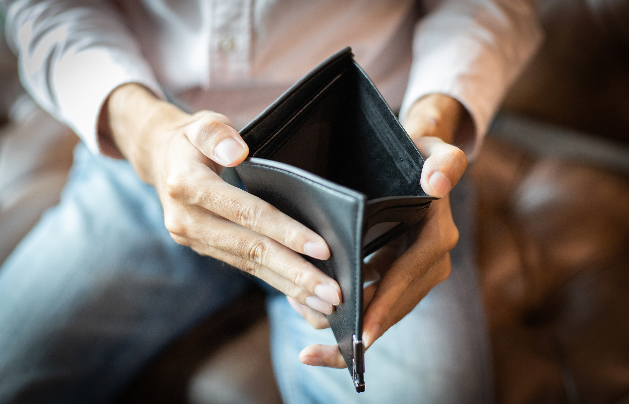 A man opening up a empty wallet.