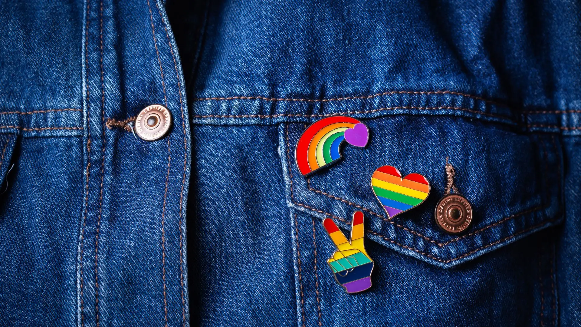 A denim jacket with pride pins.