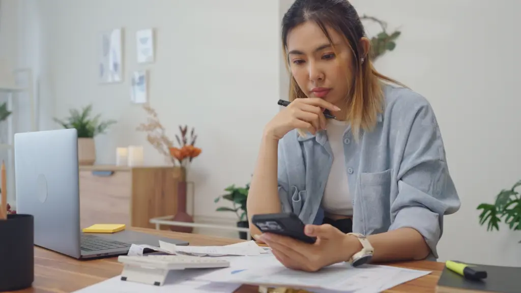A woman looking on her phone about how long she has to file a claim.