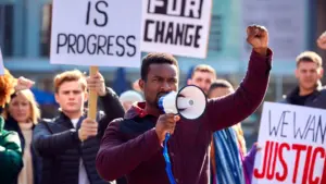 A man on the megaphone shouting at a protest.