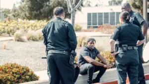 A man getting arrested by three police officers.