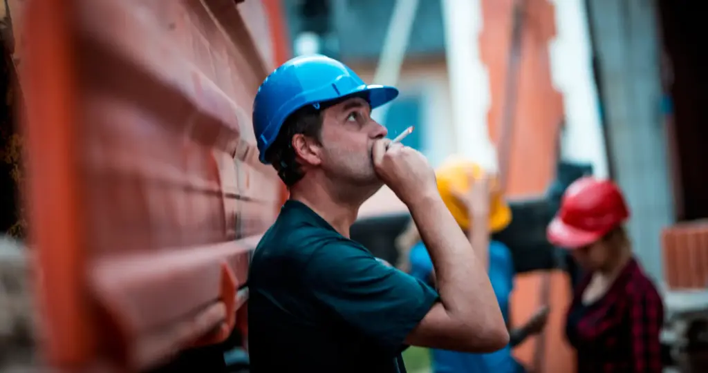 A construction worker taking a smoke break.