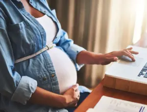 A pregnant worker on her computer.