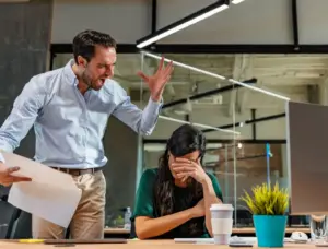 A boss shouting at his employee and she is crying.