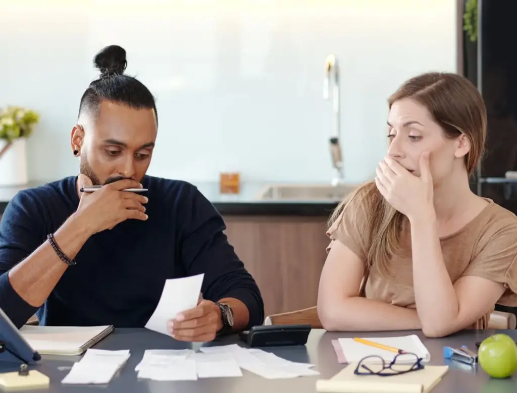 A couple going through expenses and realize that they don't have enough.