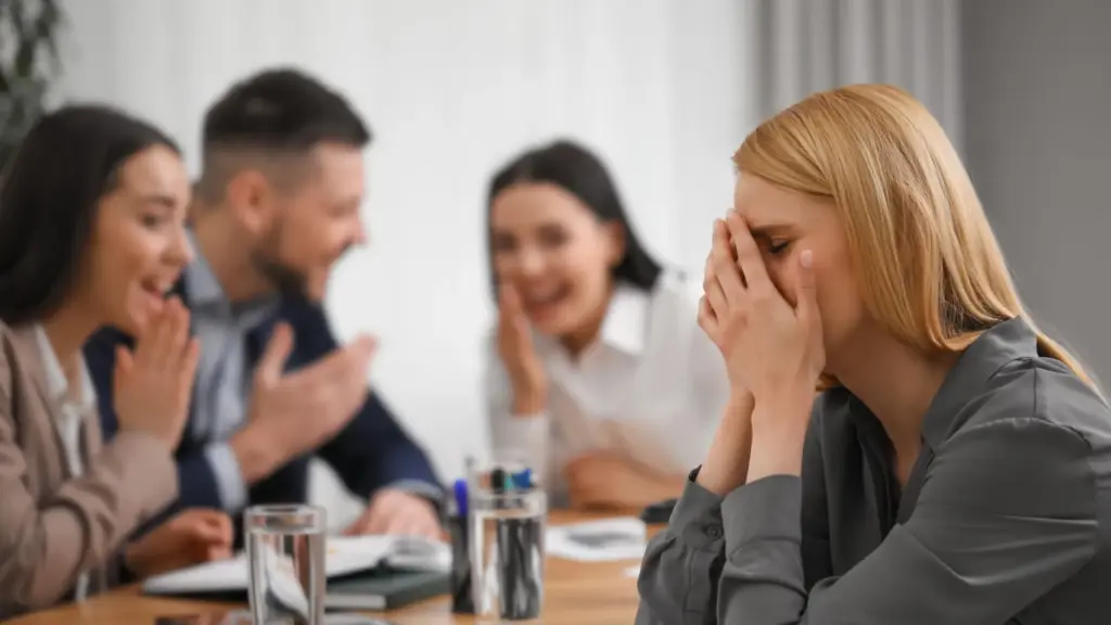 A woman getting bullied by her coworkers at work.