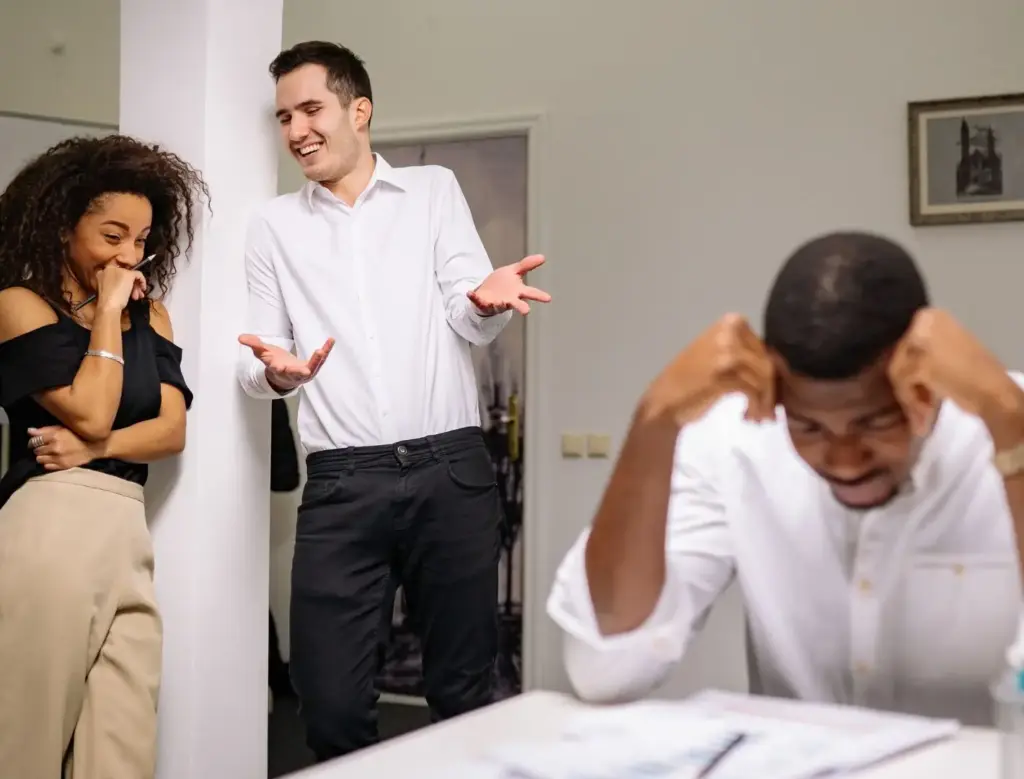 Two workers bullying their coworker. 