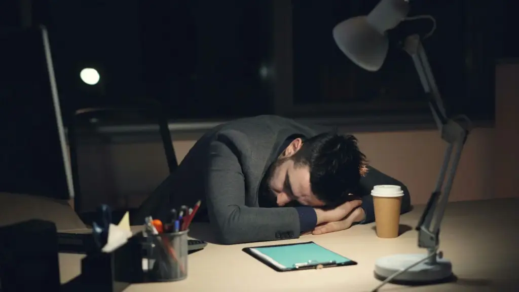 A worker sleeping at his desk at work.
