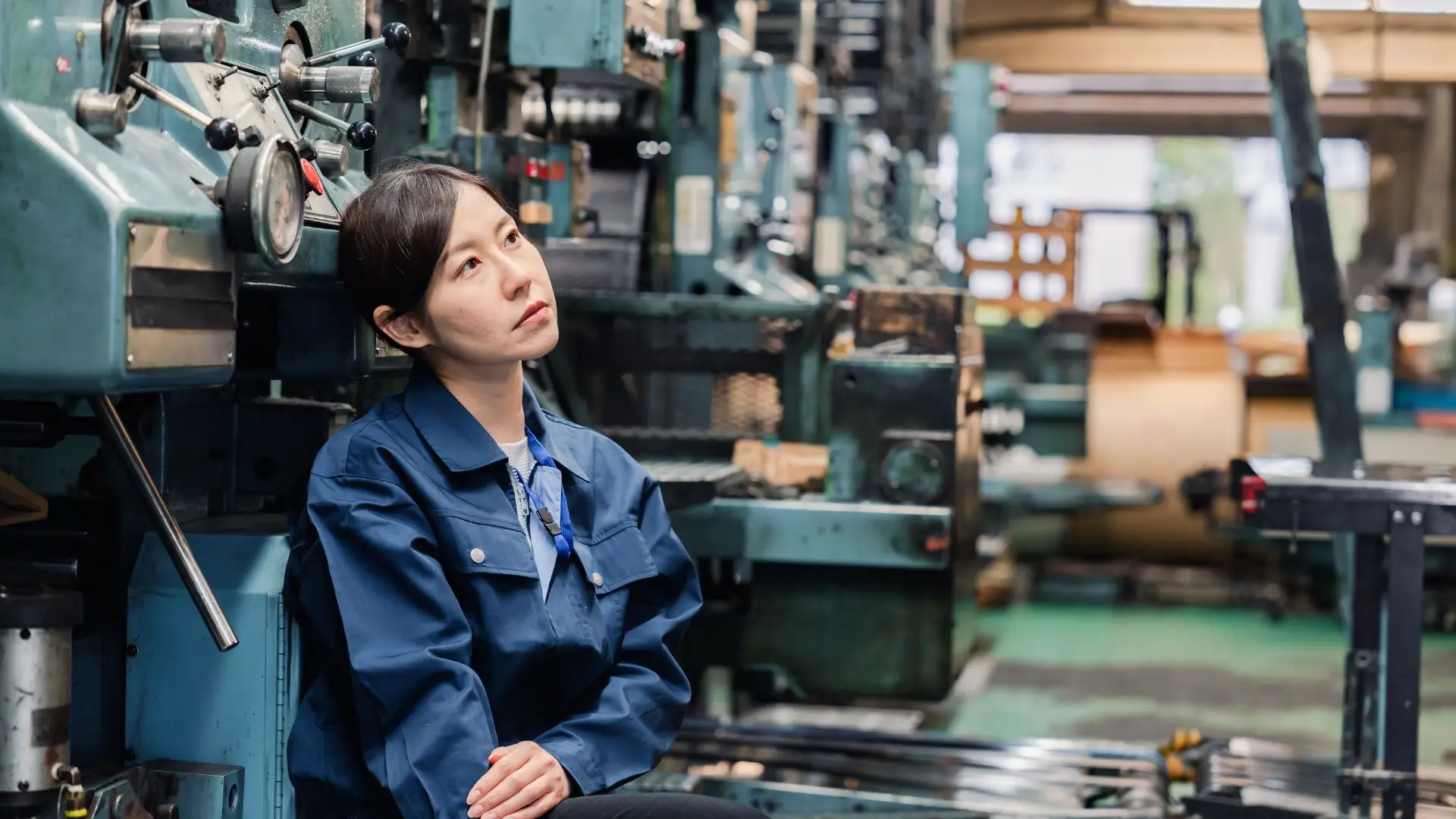 A depressed factory worker lost in her thoughts.
