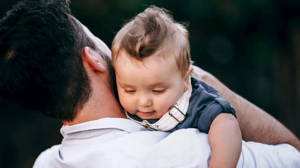 A father holding their newborn child.
