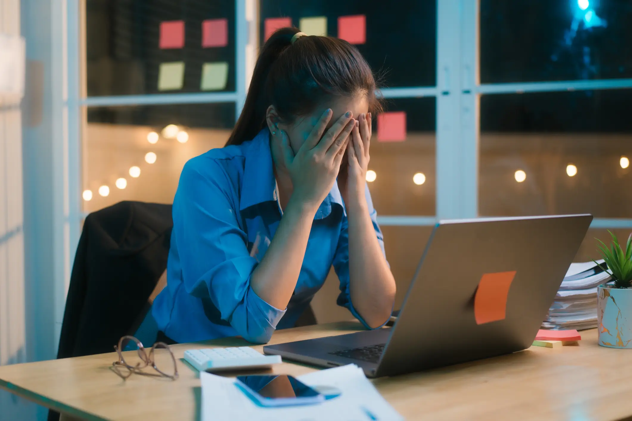 A woman putting her hands in her face, getting stressed out. 