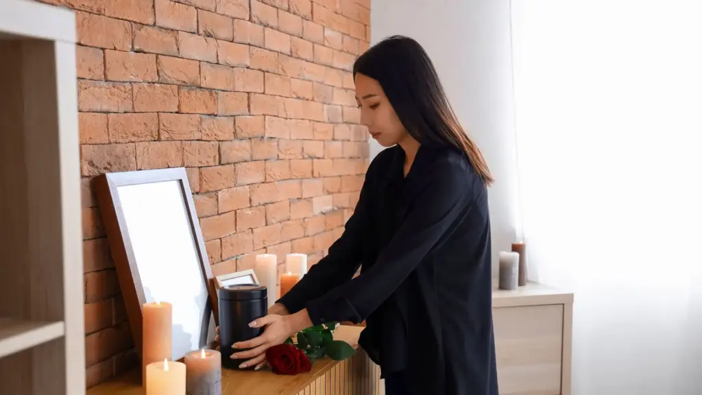 A woman placing a cremation jar in her home. 