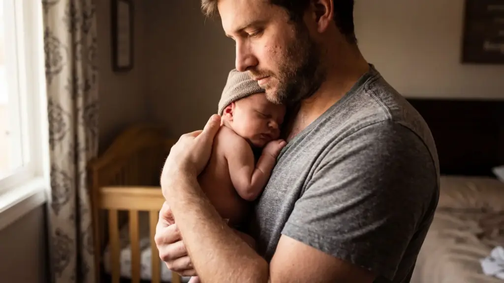 A father holding onto his newborn child.