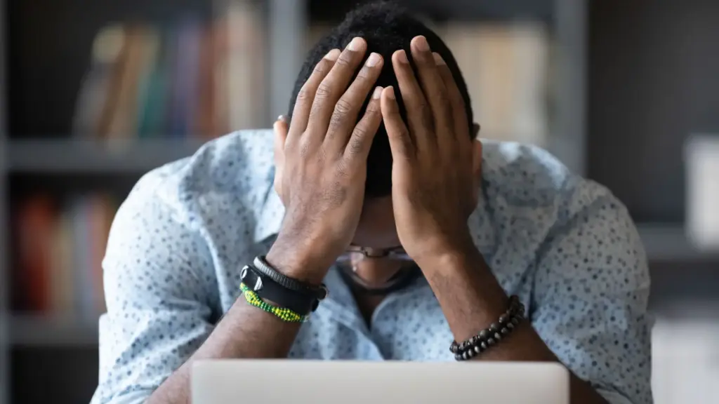 A father with his hands in his face with stress. 
