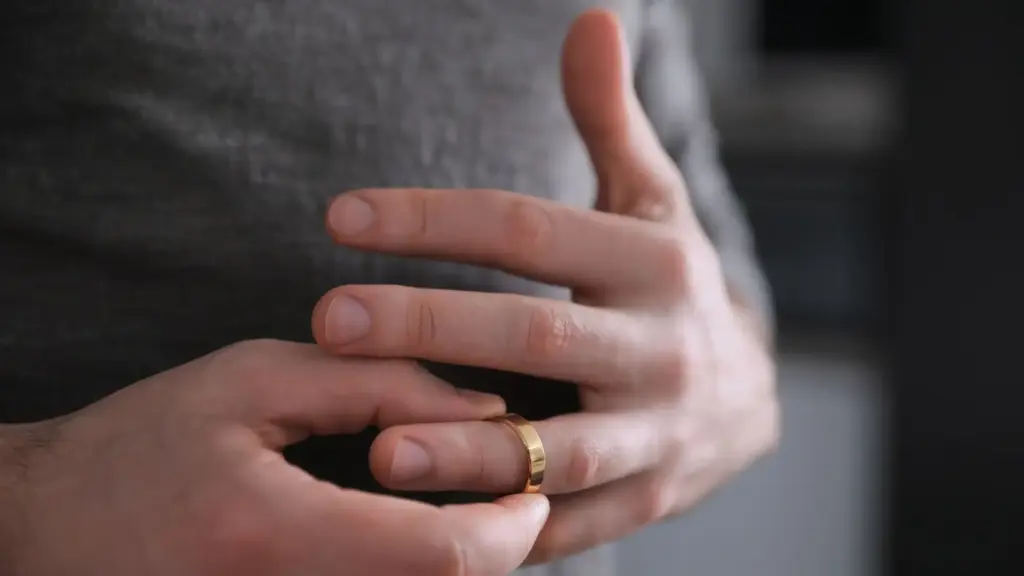 A person taking off their wedding ring. 