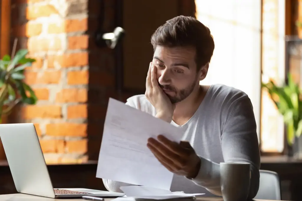 A sad man looking at his resume.