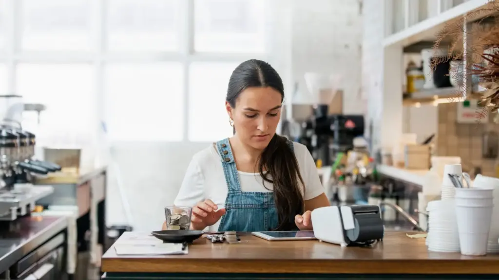 A woman calculating tips after a lunch shift. 