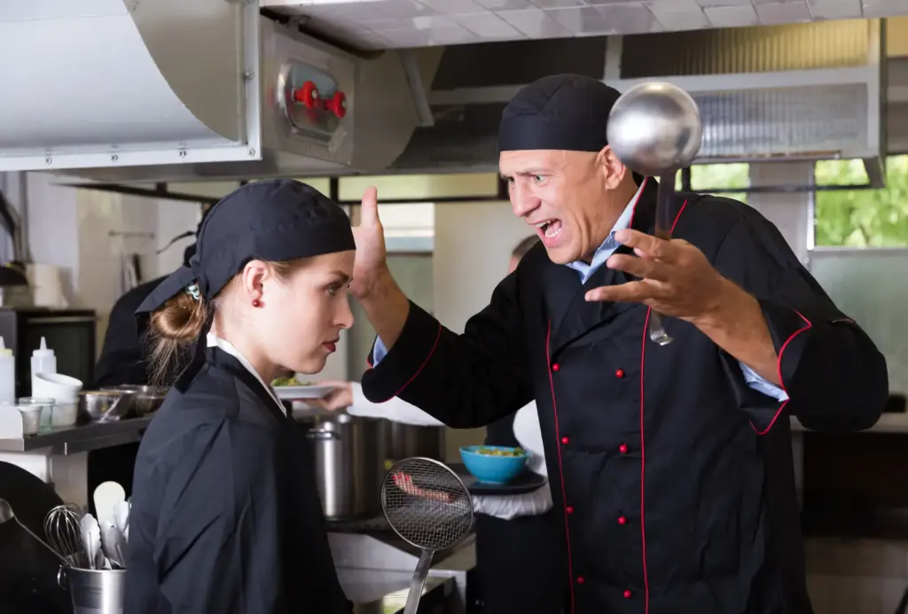 A chef yelling at a younger chef for a mistake.