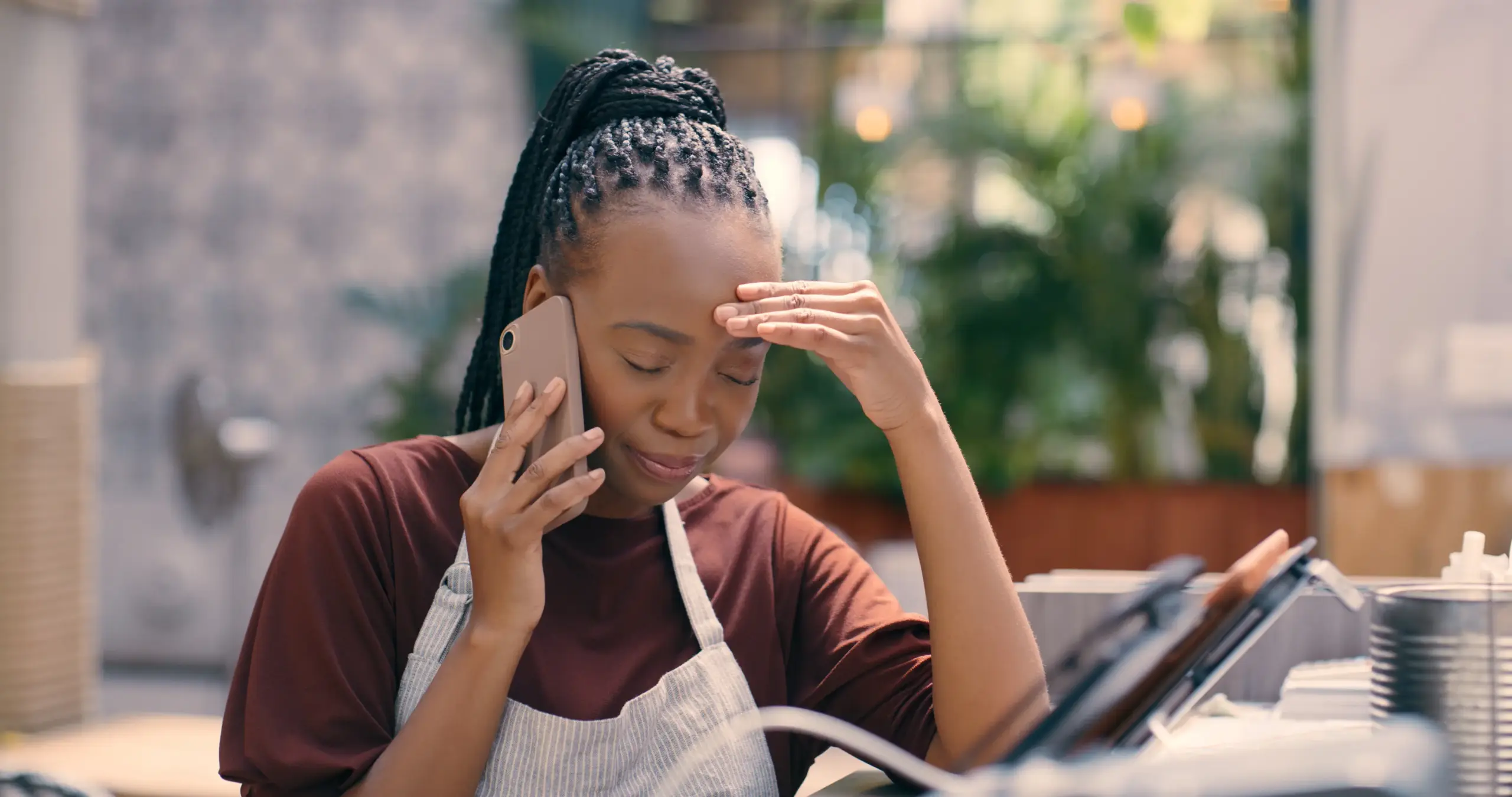 A sad cafe worker on the phone.