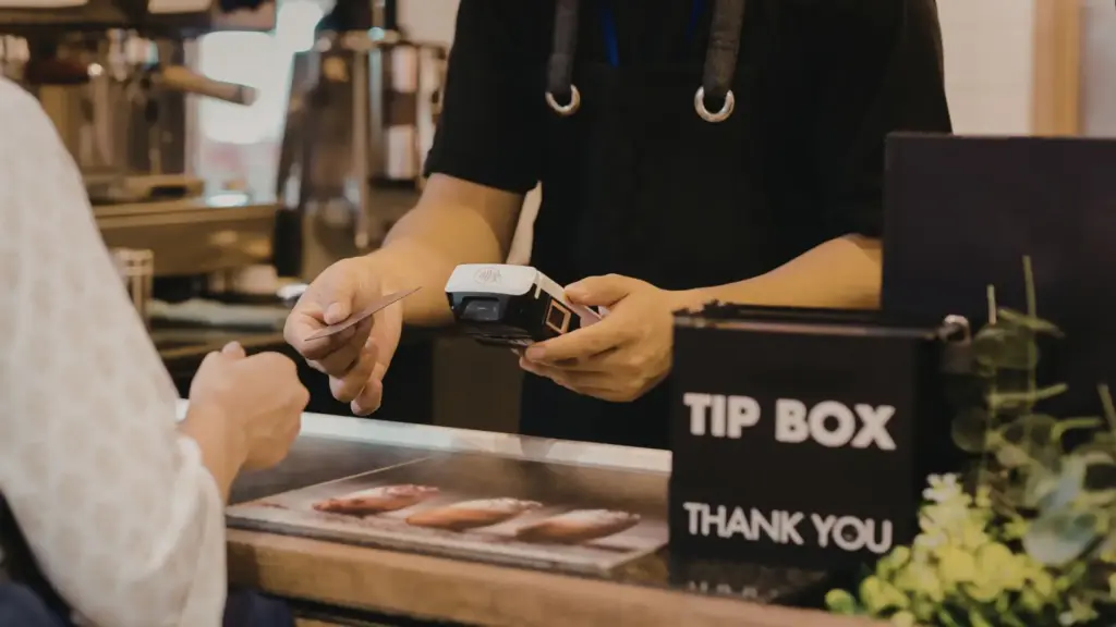 A person paying with a credit card and a cashier processing it.