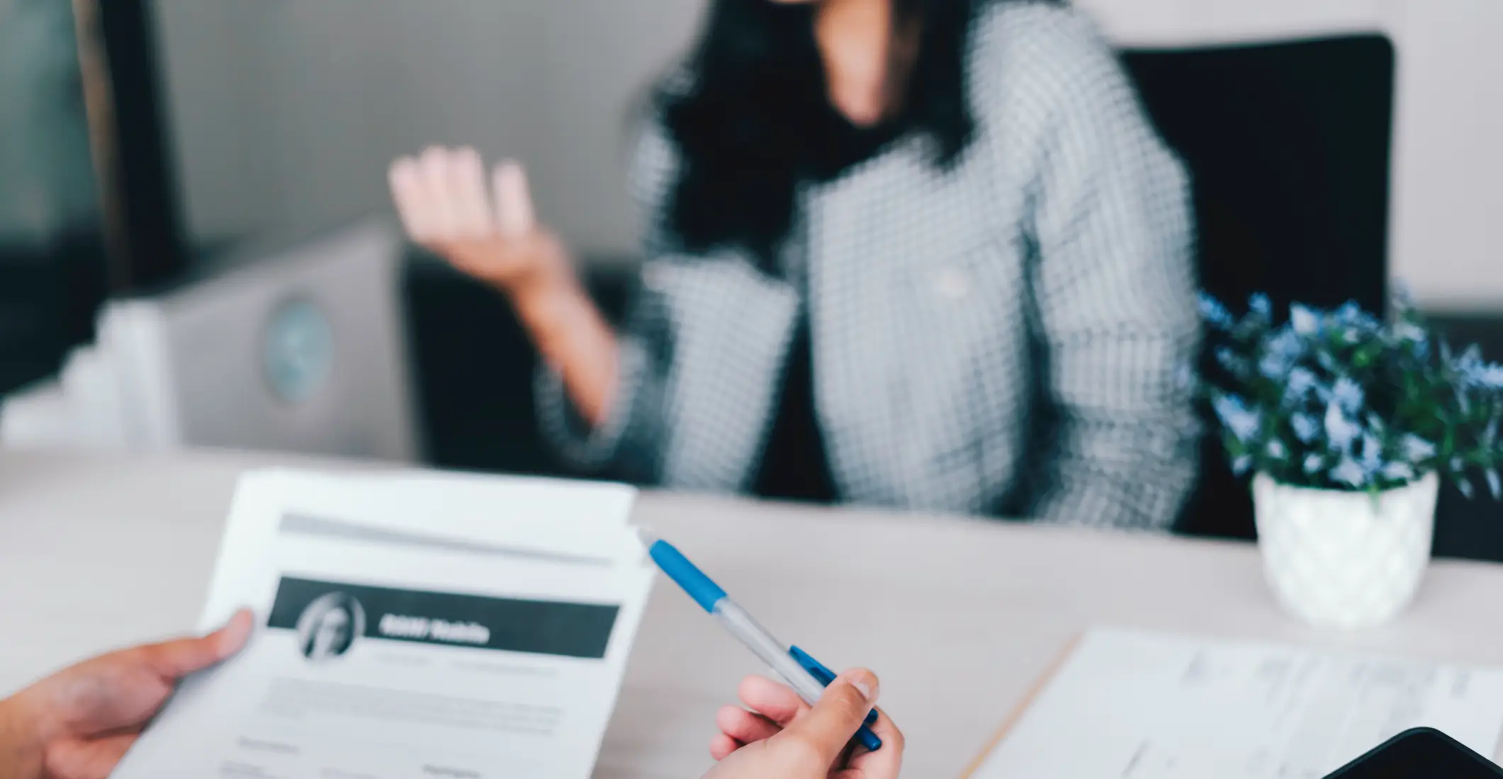 A woman in an interview and a man is looking at her resume.