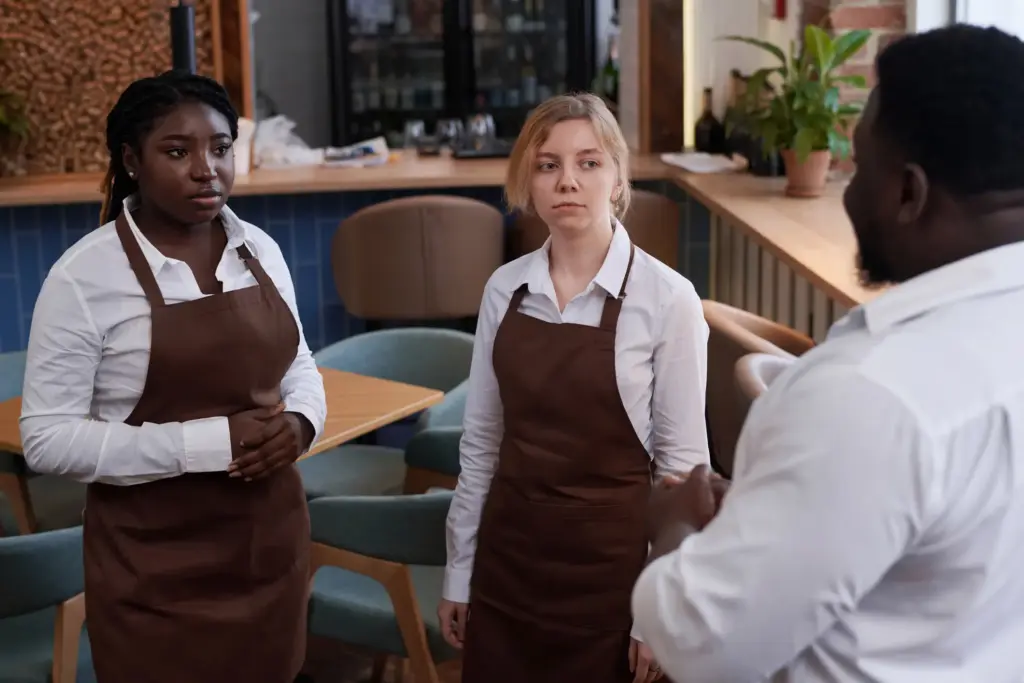 Two servers getting scolded by the restaurant manager.