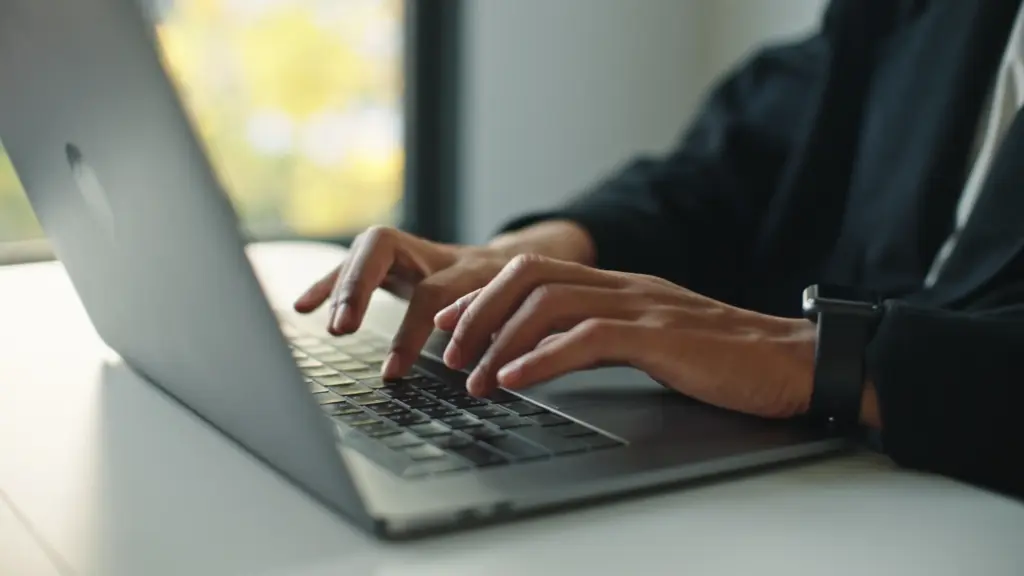 A man typing a message on a computer.