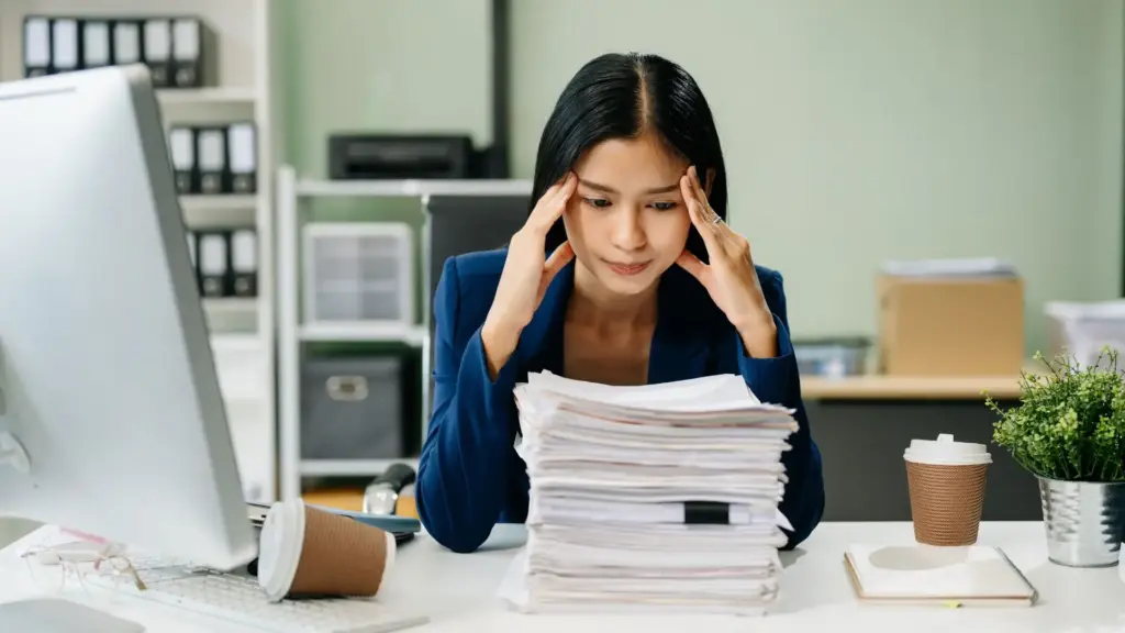 An office worker staring at a stack of papers.