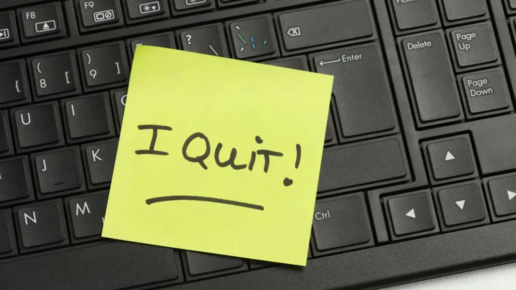 A post it note that says "I Quit!" and left on a keyboard.