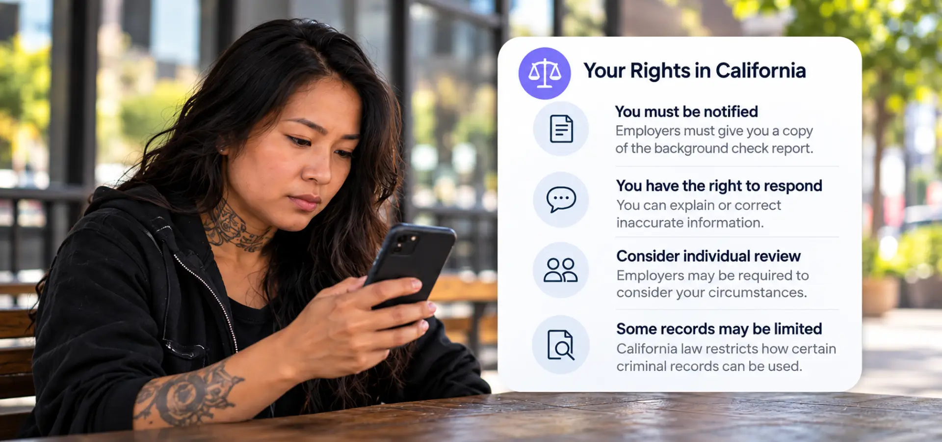 A woman with tattoos looking up her rights on her phone. 